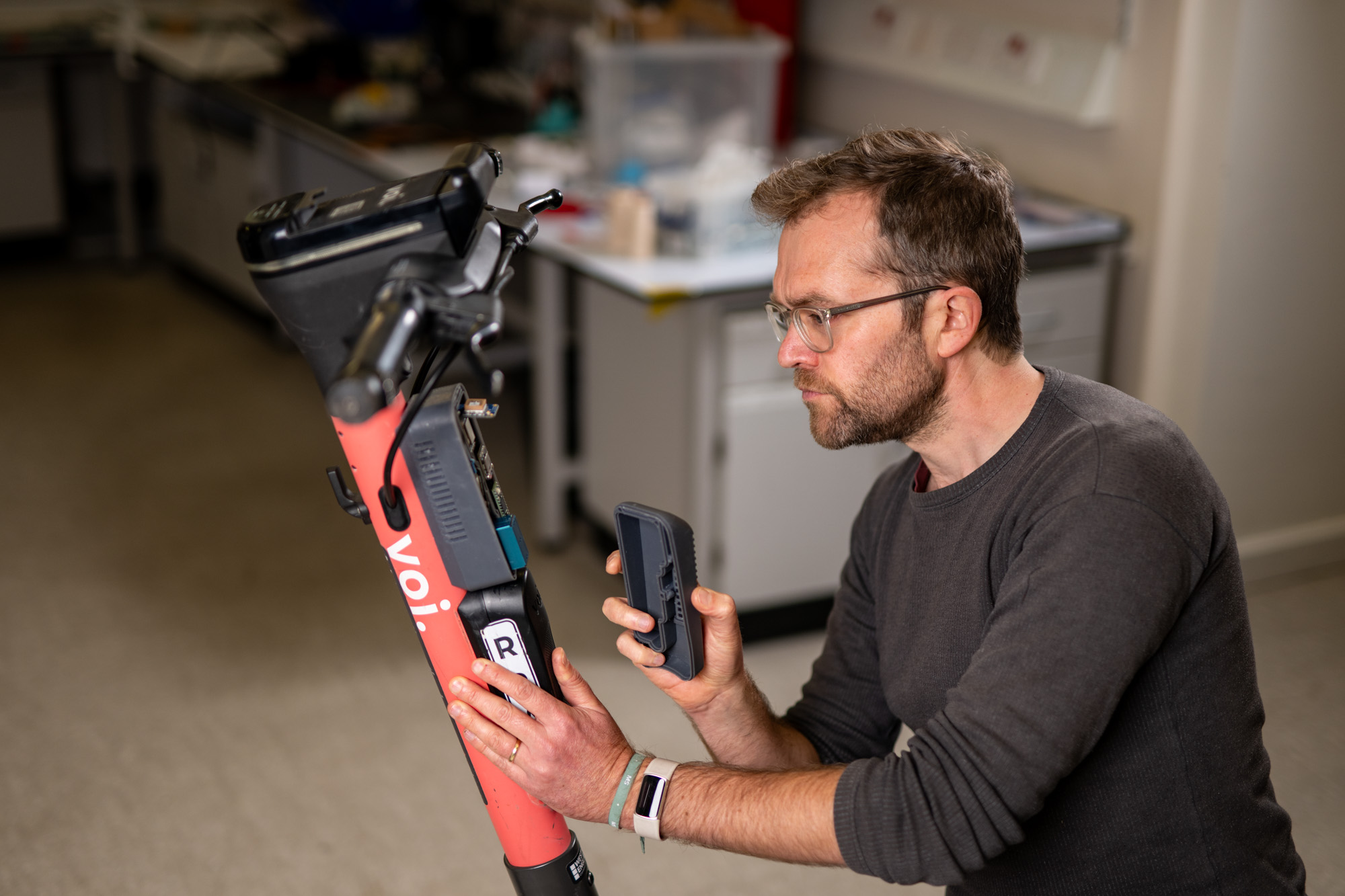 A photo of Sam Gunner working on the scooter hardware